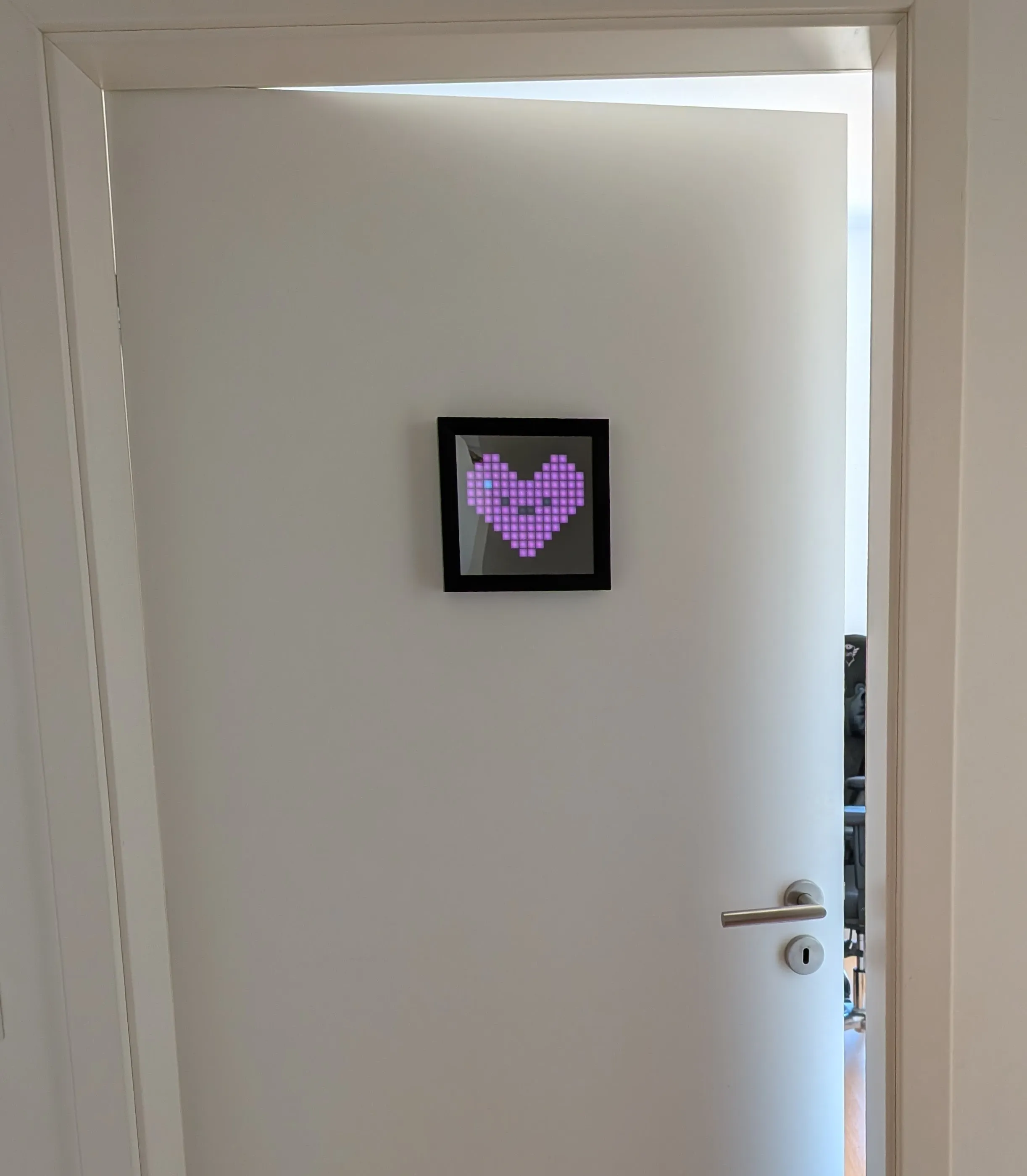 The Pixoo device mounted on a home office door